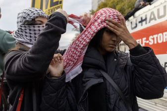 An image of two people using a Palestinian keffiyeh to show their support during a pro-Palestinian demonstration in Washington on Nov. 4, 2023.